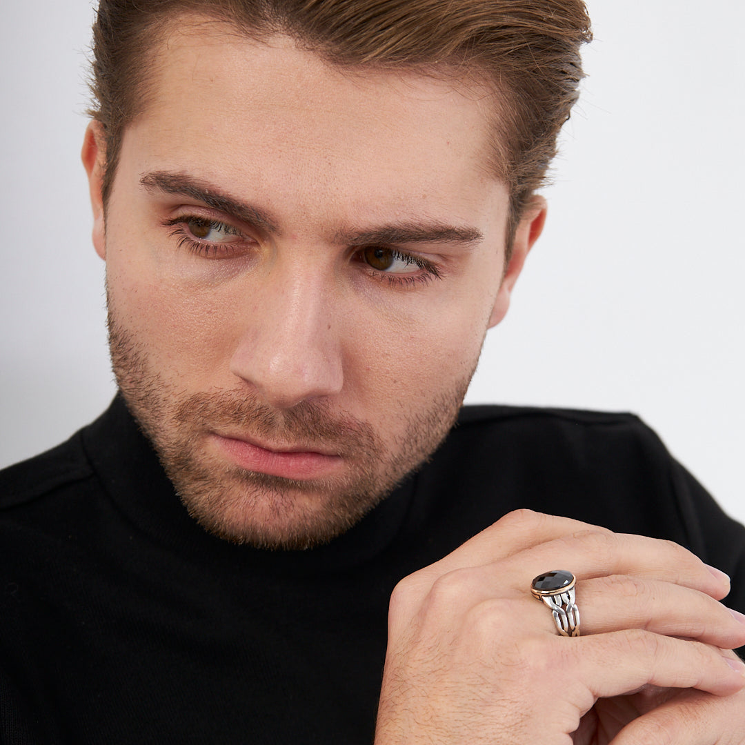 Ring with braid pattern and black stones