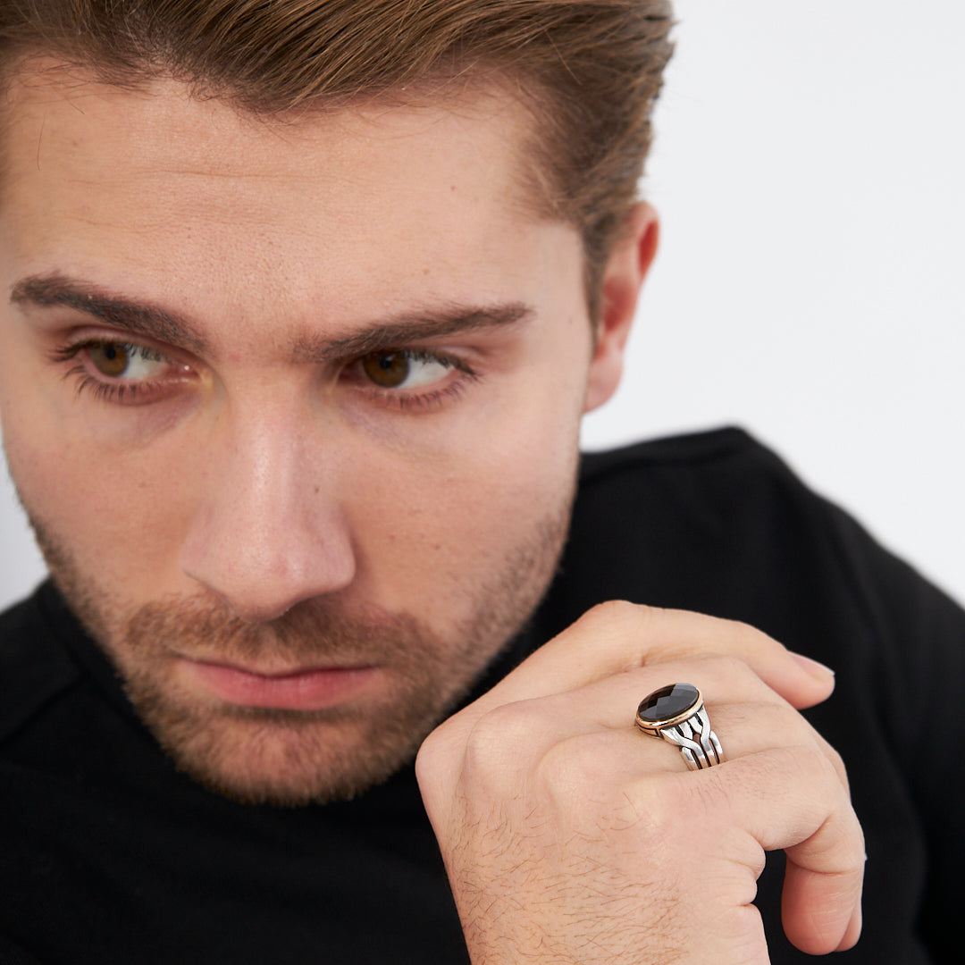 Ring with braid pattern and black stones