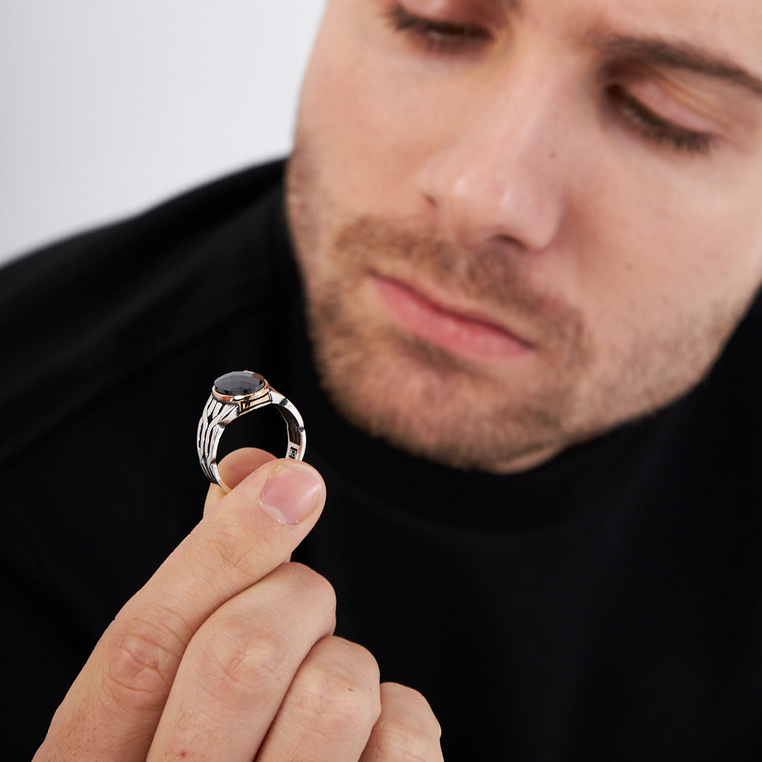 Ring with braid pattern and black stones