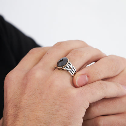 Ring with braid pattern and black stones