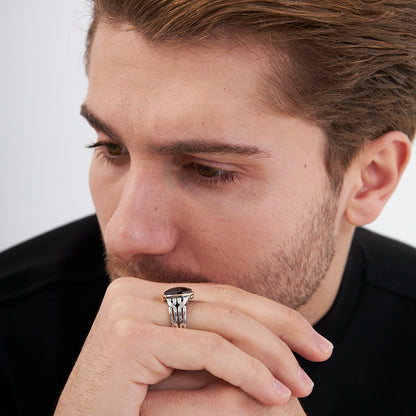 Ring with braid pattern and black stones